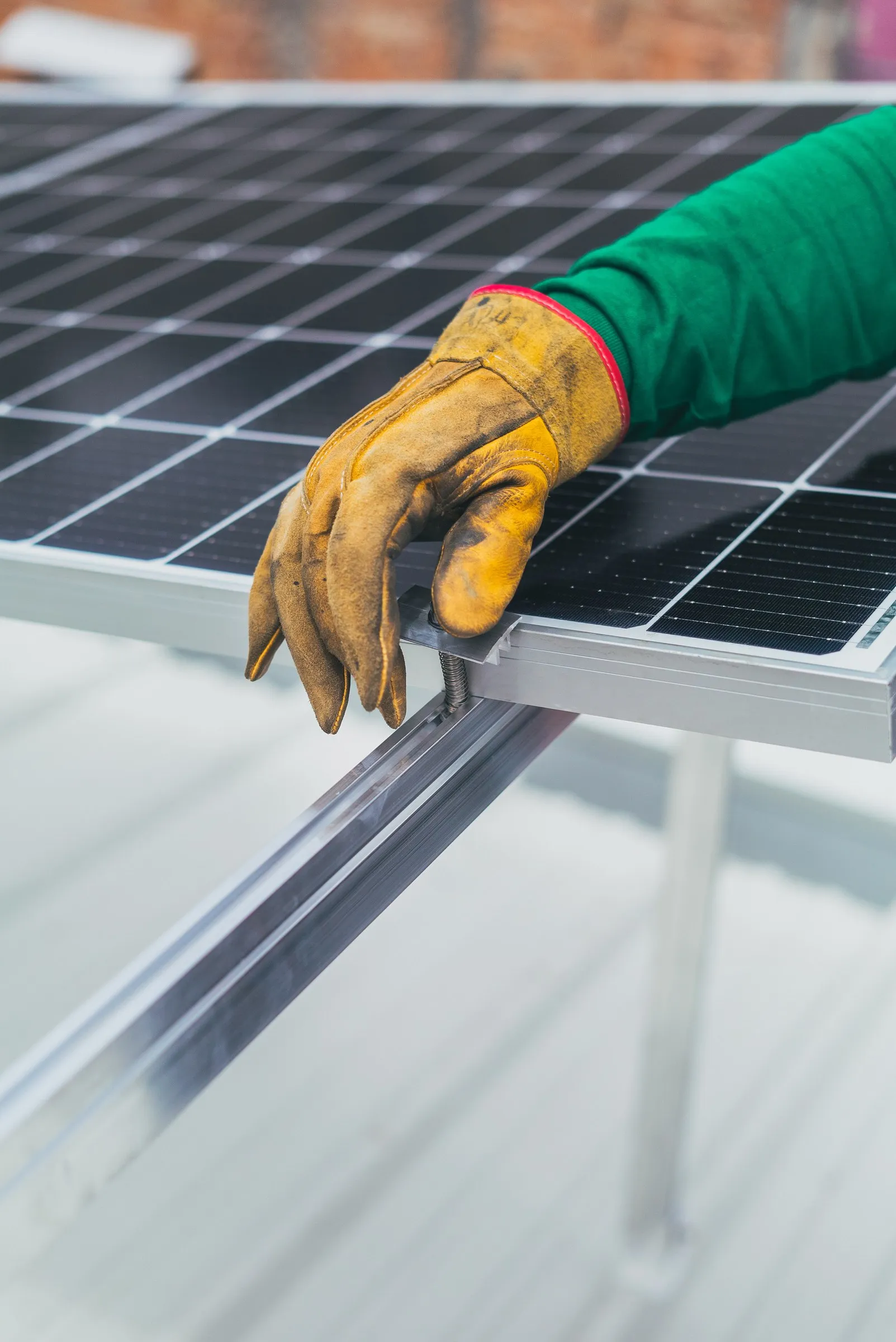 Worker wearing gloves installing solar panels